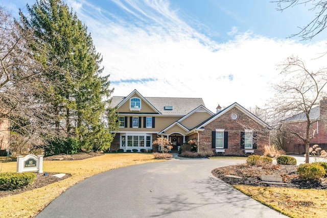 craftsman inspired home with aphalt driveway and brick siding