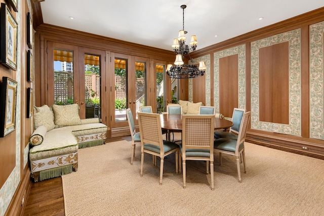 dining area with ornamental molding, french doors, a notable chandelier, and wood finished floors
