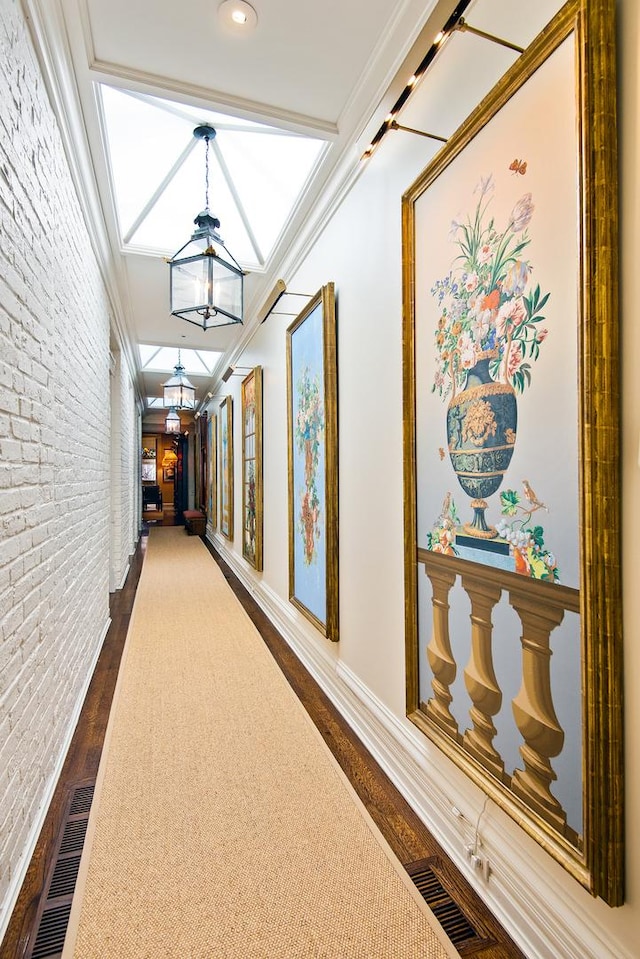 hall featuring brick wall, visible vents, dark wood-style flooring, and crown molding