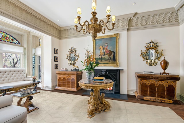 living area featuring baseboards, a chandelier, crown molding, and wood finished floors