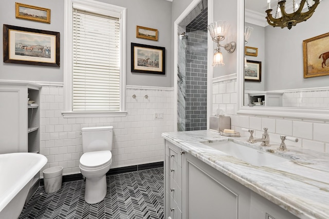 full bath with a wainscoted wall, a soaking tub, toilet, vanity, and tile patterned floors