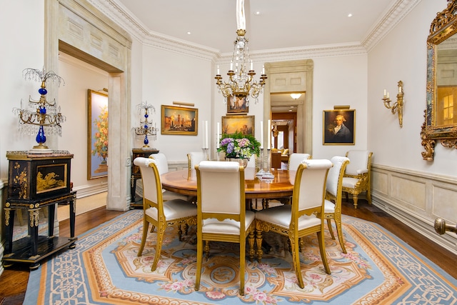 dining area featuring ornamental molding, wainscoting, dark wood finished floors, and a decorative wall