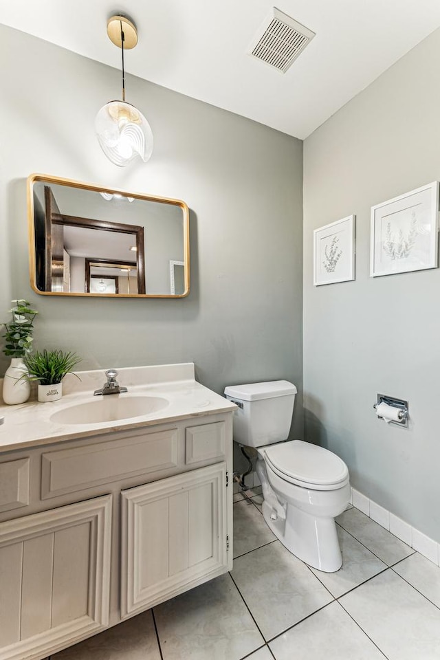 half bath featuring visible vents, toilet, tile patterned flooring, baseboards, and vanity