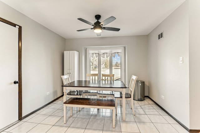 dining space featuring light tile patterned floors, baseboards, visible vents, and ceiling fan