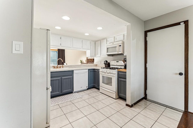 kitchen featuring gray cabinetry, recessed lighting, white appliances, light countertops, and light tile patterned floors