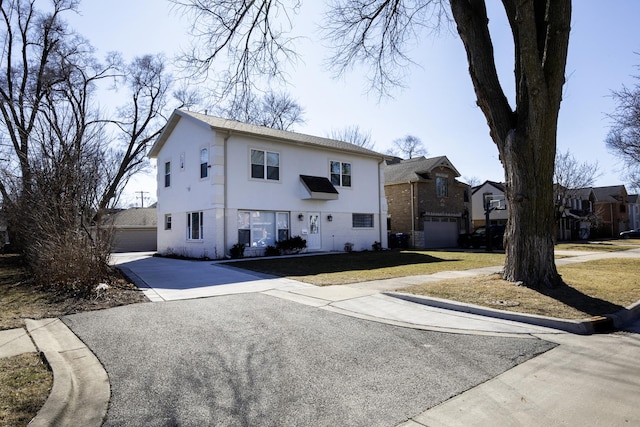 view of front of house featuring a garage, a front lawn, and stucco siding