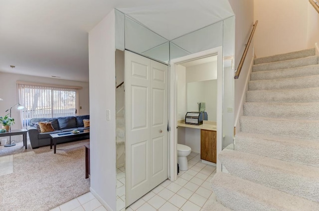 stairway with carpet and tile patterned floors