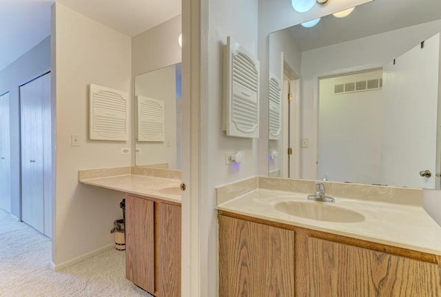 bathroom featuring visible vents, baseboards, and vanity