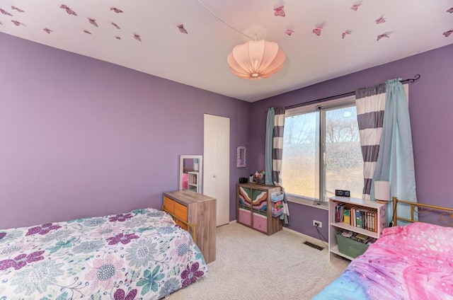 carpeted bedroom featuring visible vents