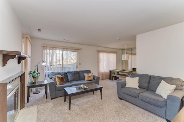 living area with light carpet, a fireplace, and visible vents