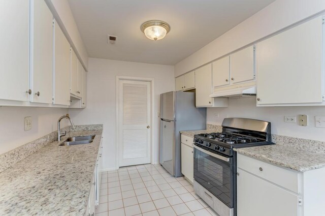 kitchen with range with gas cooktop, freestanding refrigerator, under cabinet range hood, white cabinetry, and a sink