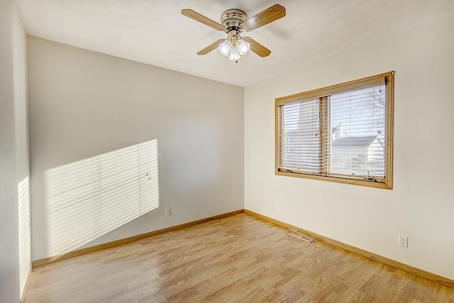 unfurnished room featuring a ceiling fan, light wood-type flooring, visible vents, and baseboards