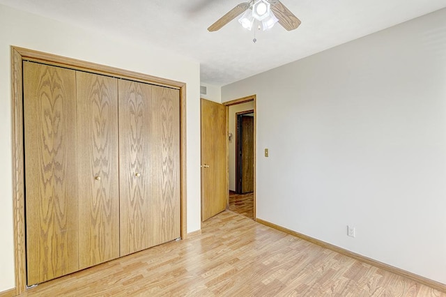 unfurnished bedroom featuring visible vents, baseboards, light wood-style flooring, ceiling fan, and a closet