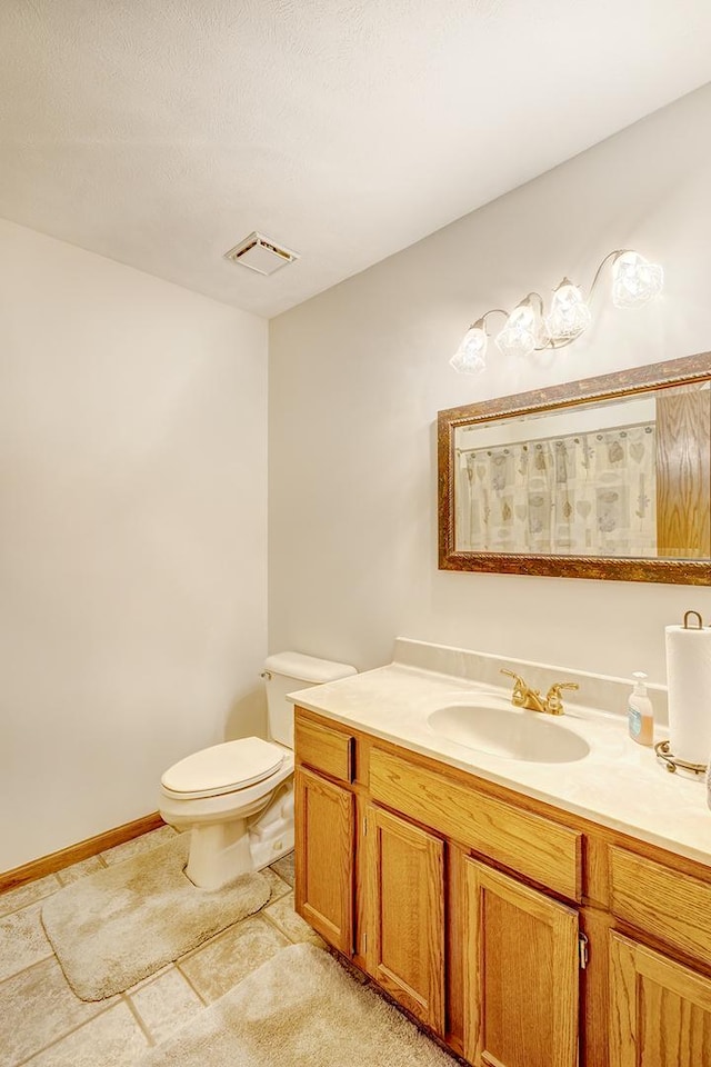 bathroom with a textured ceiling, tile patterned flooring, toilet, visible vents, and vanity