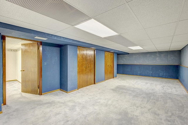 finished basement featuring carpet flooring and a drop ceiling