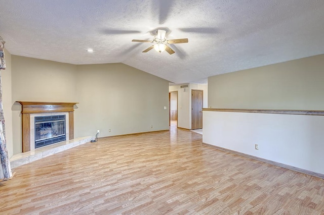 unfurnished living room featuring a premium fireplace, light wood-style floors, a ceiling fan, vaulted ceiling, and baseboards