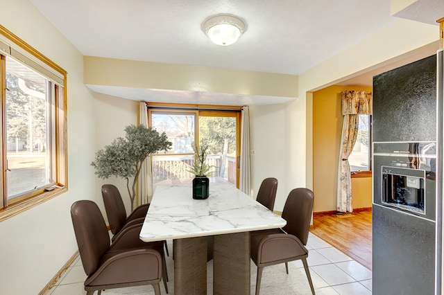 dining space with light tile patterned floors and baseboards