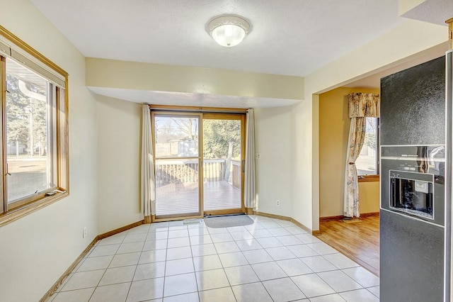 interior space featuring baseboards and light tile patterned flooring