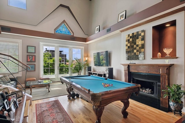 playroom featuring french doors, visible vents, a fireplace, and wood finished floors