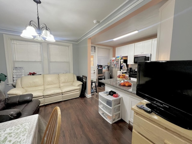 living room with dark wood finished floors and an inviting chandelier