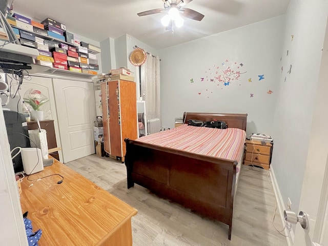 bedroom featuring ceiling fan, light wood-style flooring, and baseboards