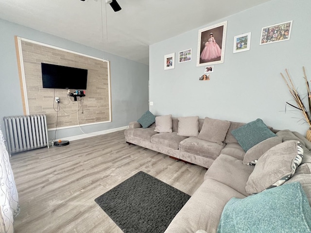 living area with ceiling fan, baseboards, wood finished floors, and radiator