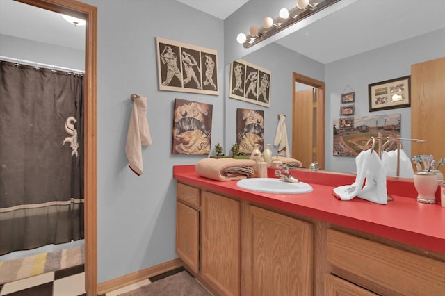 bathroom with a shower with shower curtain, vanity, and baseboards