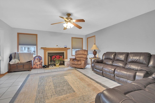 living room with a fireplace with flush hearth, ceiling fan, and tile patterned floors