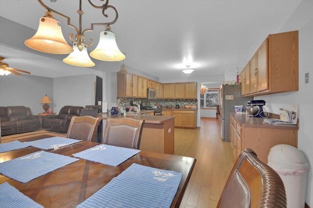 dining area featuring a ceiling fan and light wood-style floors