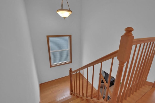 stairs with wood finished floors and baseboards