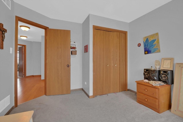 bedroom featuring carpet floors, a closet, visible vents, and baseboards