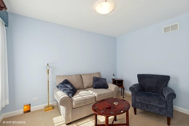 living room featuring baseboards, visible vents, and light colored carpet