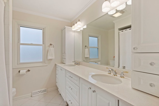 bathroom featuring crown molding, visible vents, toilet, a sink, and tile patterned flooring