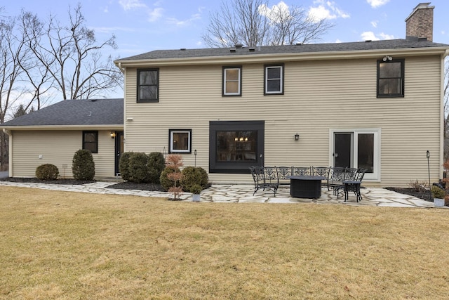 back of property featuring a patio, a chimney, and a lawn