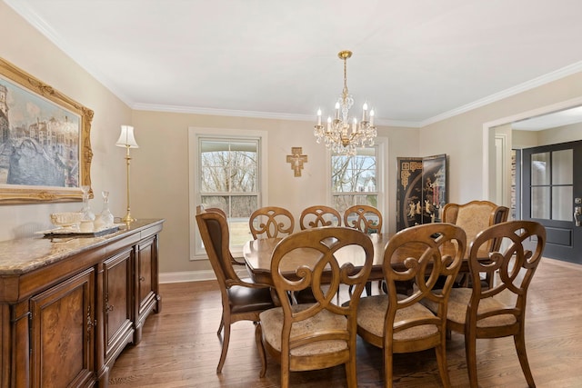 dining room with ornamental molding, wood finished floors, and a notable chandelier