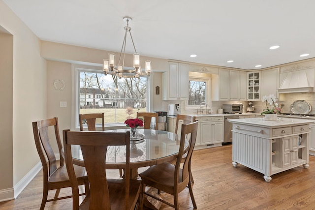 dining area featuring a toaster, baseboards, light wood-style flooring, a notable chandelier, and recessed lighting