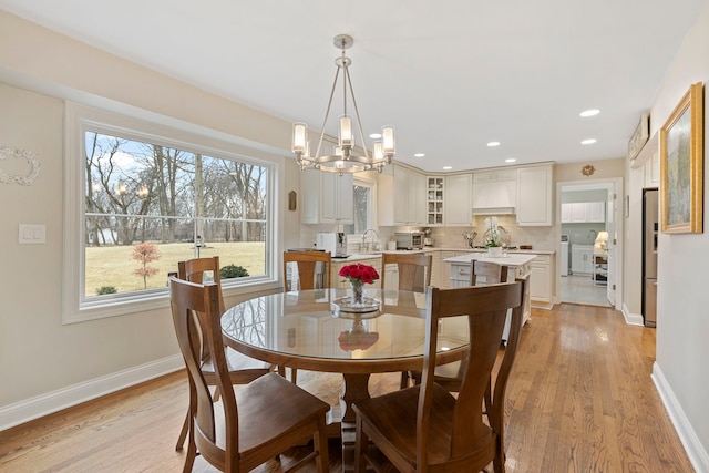 dining room with a chandelier, recessed lighting, baseboards, and light wood finished floors