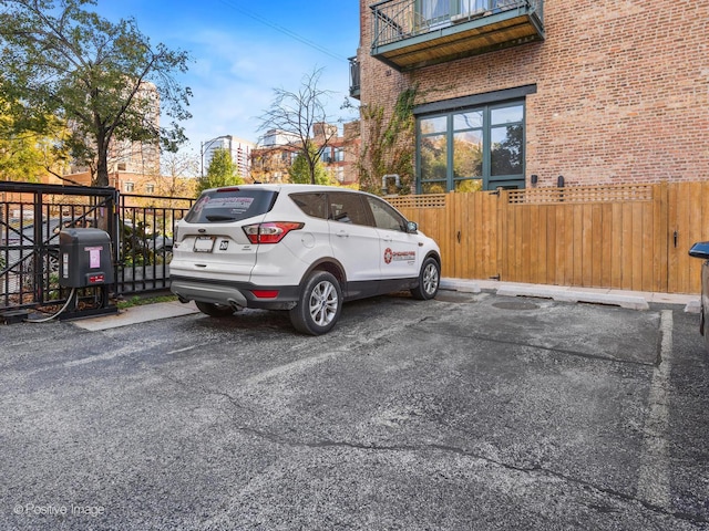 uncovered parking lot featuring fence