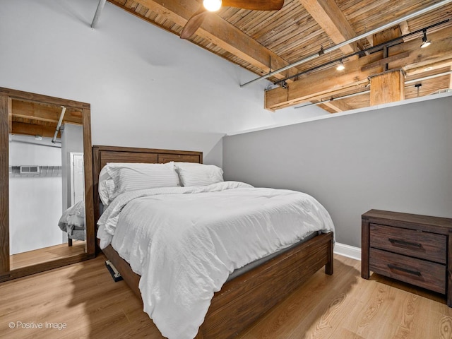 bedroom with lofted ceiling with beams, wooden ceiling, track lighting, and wood finished floors