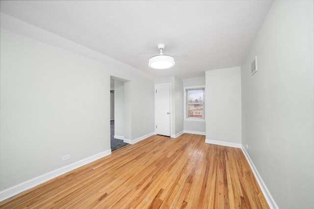 spare room with visible vents, light wood-style flooring, baseboards, and ceiling fan