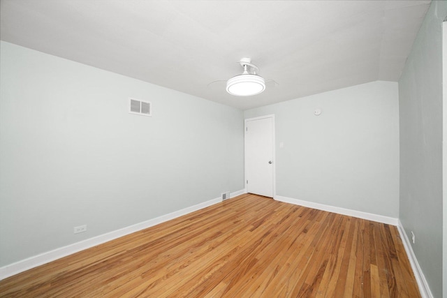 spare room with visible vents, light wood-type flooring, and baseboards