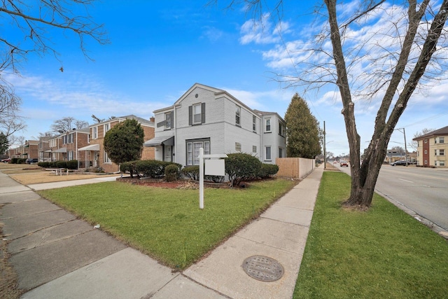 view of side of property with a yard, a residential view, and brick siding