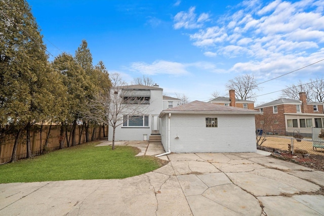 back of house featuring a patio area, a yard, fence private yard, and brick siding