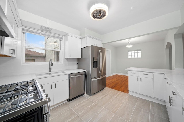 kitchen with a sink, light countertops, white cabinets, and stainless steel appliances