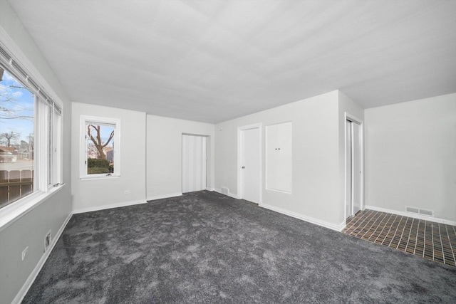 interior space with visible vents, baseboards, and dark carpet