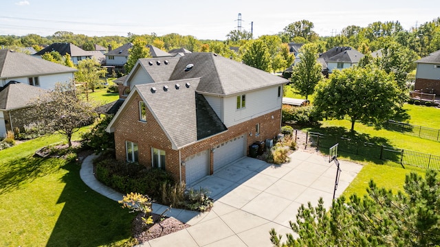 exterior space with driveway, a yard, fence, and brick siding