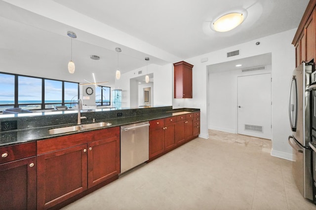 kitchen featuring appliances with stainless steel finishes, reddish brown cabinets, visible vents, and a sink