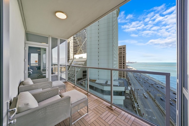 balcony featuring a view of city, a beach view, and a water view