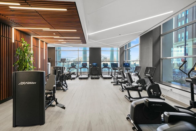 exercise room with floor to ceiling windows and wood finished floors