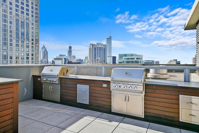 view of patio / terrace with exterior kitchen, grilling area, and a city view